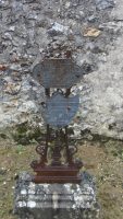 tombe pleine terre avec stèle en pierre surmontée d'une croix métal sur laquelle sont gravés 2 écussons au nom des décédés -natty