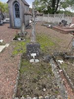tombe pleine terre entourée de bordures avec croix ouvragée et plaque cassée -natty