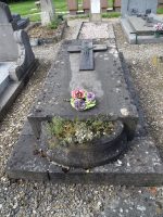 monument en pierre grise avec croix posée dessus et jardinière en demi cercle en façade - natty