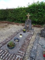 petite tombe gravillonnée entourée d'une bordure briquette avec petite stèle surmontée d'une petite croix, et macaron du Souvenir Français - Natty