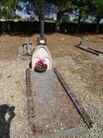 petite tombe gravillonnée avec bordurette pierre, stèle en pierre surmontée d'une croix métal ouvragée - natty
