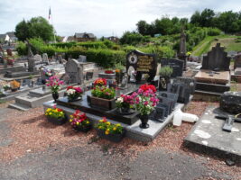 grand monument avec de nombreuses plaques et photos, jardinière initiales L.F. et stèle gravée en lettres noires sur fond doré - natty
