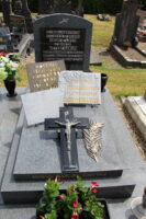monument gris bleu avec stèle sur laquelle est fixée une plaque noire commémorative- 3 autres plaques ainsi qu'une croix posée sur la pierre tombale - A.Demolder