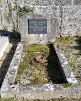 petite tombe entourage pierre avec stèle sur laquelle est fixée une place d'identification noire en bon état - nharant