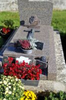 monument grès moucheté gris rose avec stèle gravée et croix posée sur la pierre tombale, espace jardinière en façade - nharant