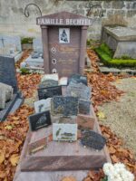 petit monument rose avec stèle haute sur laquelle figure les prenoms des 3 défunts de la famille, leur photo devant chaque prénom, et une photo de motard au dessus - o.Dufour