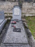 Pierre tombale en pierre grise avec stèle sur laquelle est fixée une plaque blanche d'identification - O.Dufour