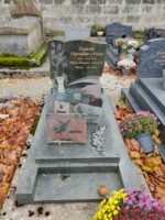 monument gris avec stèle noire sur laquelle est incrusté à gauche un bouquet de fleurs grise et à droite identification des défunts en lettres dorées stylisées - O.Dufour