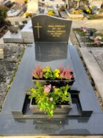 monument noir avec stèle gravée en lettres dorées, et à gauche croix dorée, en façade espace jardinière - O.Dufour  