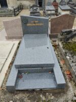 monument gris avec stèle en forme de trapeze. une tête de Christ en haut à gauche et identification de la famille en lettres dorées - O.Dufour