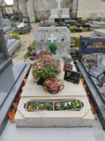 monument en pierre blanche avec espace jardinière en façade, et stèle de couleur grise avec croix et photo du couple défunt de chaque côté de la croix -O.Dufour