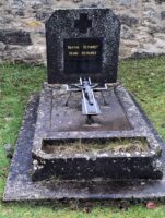 monument ancien, en pierre avec stèle sur laquelle est fixée une plaque d'identification noire, avec croix sur la pierre tombale et espace jardinière en façade - nharant
