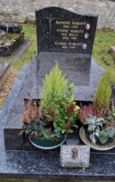 monument noir avec stèle gravée et photos des défunts, et à gauche petite croix, en façade espace jardinière - nharant