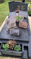 monument gris avec stèle gravée et espace jardinière en façade -nharant