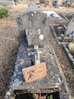 monument ancien en  pierre grise avec stèle sur laquelle sont incrustés une croix et deux fleurs de chaque côté, et sur la pierre tombale, une croix et deux plaques avec photo du couple et identification - O.Dufour