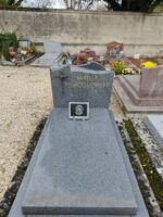 monument gris avec stèle gravée en lettres dorées sur laquelle est fixée à gauche une croix avec fleur - O.Dufour