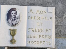 plaque posée sur la pierre tombale, avec photo et croix de guerre