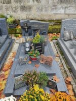 monument gris avec stèle sur laquelle est fixé un crucifix à gauche des inscriptions. sur la pierre tombale, une plaque avec photos des défunts - O.Dufour