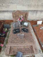 monument moucheté rose et gris avec stèle sur laquelle est gravée une croix dorée à gauche de l'identification - O.Dufour