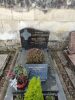 monument gris foncé avec stèle noire sur laquelle figure une tête de christ à gauche de la  gravure. sur la pierre tombale une plaque d'identification et espace jardinière en façade - O.Dufour