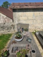 monument gris avec stèle sur laquelle figurent une croix dorée et deux colombes à gauche de l'identification -O.Dufour