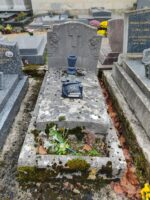 monument en pierre, ancien, avec stèle sur laquelle est incrustée une croix avec une fleur de chaque côté. le nom de la famille est en bas - O.Dufour