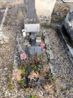 petite tombe entourage pierre et gravillons, avec croix et plaques, stèle au bas de laquelle est fixée une plaque d'identification - O.Dufour