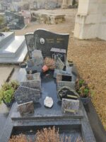 monument gris foncé avec stèle sur laquelle figure à gauche de l'identification, un motif fleuri et une photo du défunt - O.Dufour