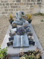 pierre tombale grise avec identification sur une plaque en forme de livre, et en lieu et place d'une stèle, une statue de femme agenouillée, tête baissée dans ses mains - O.Dufour