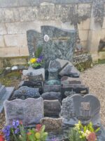 monument gris, entièrement couvert de plaques, avec stèle sur laquelle figure une photo du défunt à gauche de l'identification - O.Dufour
