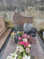 monument marbré rose et gris avec stèle forme fantaisie gravée en lettres dorées. a gauche figure une main tenant un bouquet de fleurs - O.Dufour