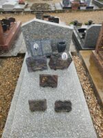 monument gris moucheté avec stèle gravée au nom de la famille. l'identité des défunts ainsi que leur photo figurent sur 2 plaques posées sur la pierre tombale - O.Dufour