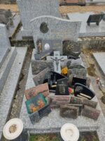 monument gris moucheté avec stèle gravée au nom des défunts et une tête de christ à gauche , Nombreuses plaques dont une avec photo - O.Dufour