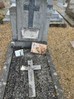 petite tombe entourage pierre et gravillons et stèle sur laquelle est fixée une plaque d'identification blanche sous une croix. Sur les gravillons, une croix et une plaque avec photo de la défunte - O.Dufour