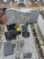 monument moucheté gris et blanc avec stèle gravée en lettres dorées et fleurs blanches à gauche de l'inscription - O.Dufour