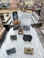 monument gris moucheté avec stèle sur laquelle figure une photo du couple défunt à gauche de l'inscription en lettres blanches, et un bouquet sur fond noir - O.Dufour