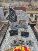 monument gris moucheté avec stèle gravée et photo du défunt, et à gauche sur fond noir, fleurs et épis - O.Dufour 
