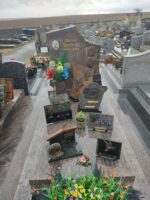 monument gris marbré rose avec stèle sur laquelle figurent 2 fleurs à droite, l'identification en lettres dorée au milieu, et à gauche une photo du défunt - O.Dufour