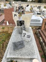 pierre tombale gris moucheté avec stèle couleur pierre sur laquelle figure une photo à gauche et l'identification à droite de l'ouverture