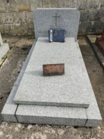 monument gris avec stèle sur laquelle figure une croix dorée au dessus de l'identification - O.Dufour