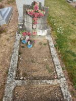 petite tombe entourage pierre avec stèle sur laquelle figure une croix garnie de roses. une plaque d'identification au pied de la stèle - o.Dufour