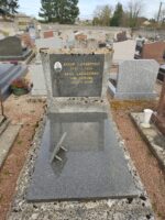 pierre tombale gris foncé avec entourage pierre, et stèle sur laquelle figure l'identification du couple défunt ainsi qu une photo - O.Dufour