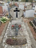 tombe en pierre avec stèle en éventail sur laquelle figure une croix. sur la pierre tombale plaque rédigée en espagnol, croix et espace jardinière en façade - O.Dufour