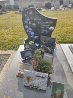 monument gris marbré avec stèle sur laquelle figure la photo du couple défunt à droit, l'identification au milieu et une branche de fleurs bleues à gauche. sur la pierre tombale figure une autre photo d'un jeune homme - O.Dufour