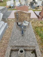 monument gris moucheté avec stèle sur laquelle figure une vierge à gauche de l'identification du défunt,et une croix sur la pierre tombale - O.Dufour