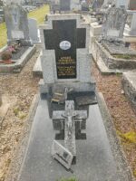 Pierre tombale grise avec stèle sur laquelle figure une grande plaque noire en forme de croix avec la photo du couple défunt et leur identification en lettres dorées - O.Dufour