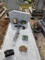 monument gris moucheté avec croix posée sur la pierre tombale, et stèle sur laquelle figure une photo à gauche de l'identification difficilement lisible - O.Dufour