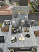 monument gris moucheté avec stèle sur laquelle est identifiée la famille. Plusieurs plaques avec photo sur la pierre tombale - O.Dufour