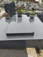 très large monument gris foncé avec pierre tombale centrale, et identification des défunts de chaque côté -O.Dufour