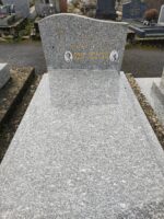 monument gris moucheté avec stèle sur laquelle figure 2 photos et l'identification du couple défunt ainsi qu'une croix dorée à gauche - O.Dufour